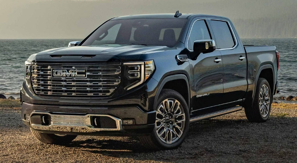 A black 2025 GMC Sierra 1500 Denali Ultimate parked near a lake.