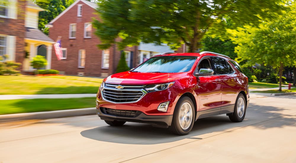 Red 2018 Chevy Equinox driving down an open road.