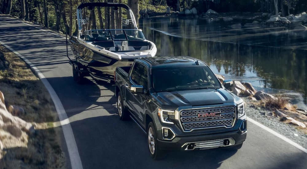 A black 2022 GMC Sierra 1500 towing a boat.