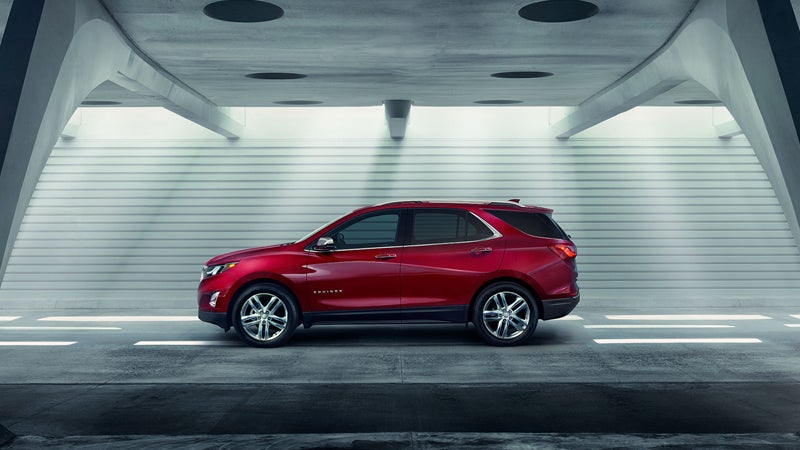 Side view of a red 2019 Chevrolet Equinox parked, showcasing its sleek design and modern SUV profile.