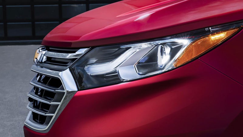 Side view of a red 2019 Chevrolet Equinox, highlighting its sharp headlights.