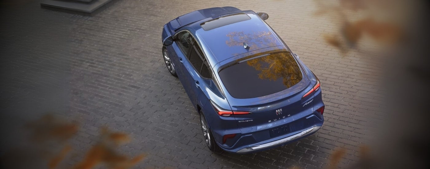 A blue 2024 Buick Envista Avenir is parked on a stone driveway.