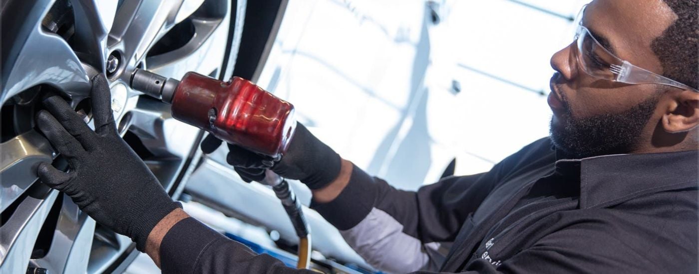 A technician is shown installing a wheel at a Chevy dealer.