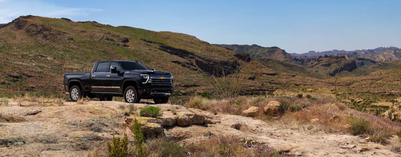 A black 2025 Chevy Silverado 2500 parked off-road.
