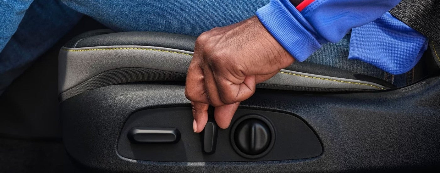 A person is shown adjusting a seat in a 2024 Chevy Trax.
