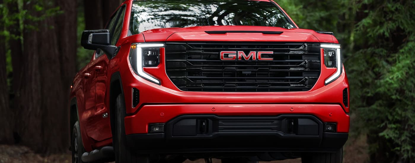Red 2026 GMC Sierra 1500 for sale near Greenville parked in a forest.