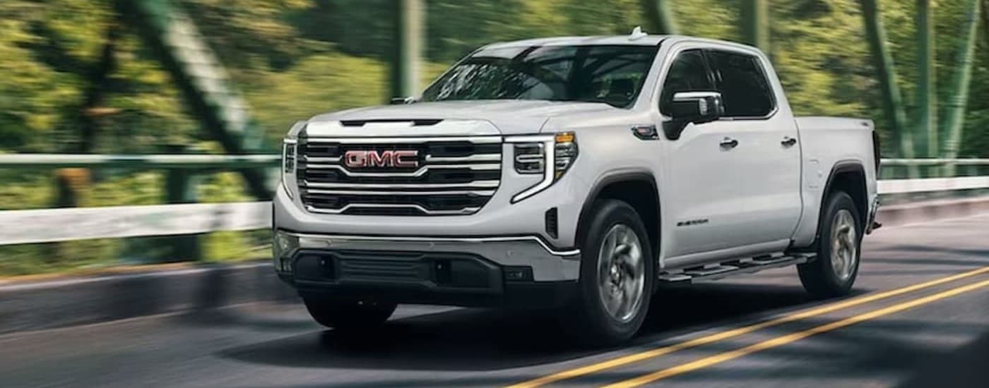 A white 2024 GMC Sierra 1500 for sale near Clarksville driving on a bridge.