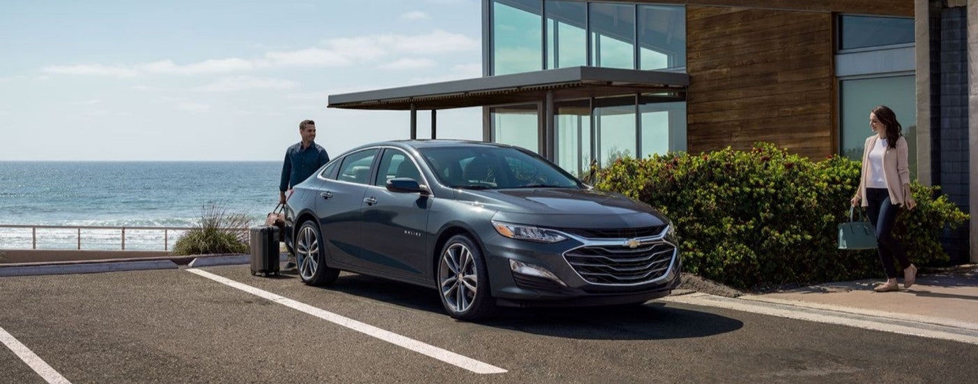 A grey 2022 Chevy Malibu is parked outside of a hotel after leaving a used Chevy dealer.