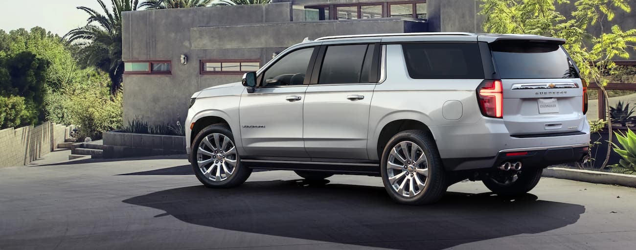 Rear of a white 2021 Chevy Suburban parked near a building.