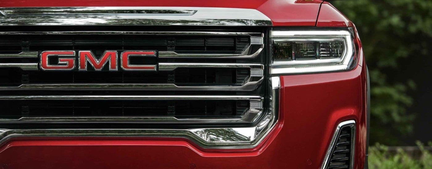 A close up of the front of a red 2022 GMC Acadia SLE at a used GMC dealer.